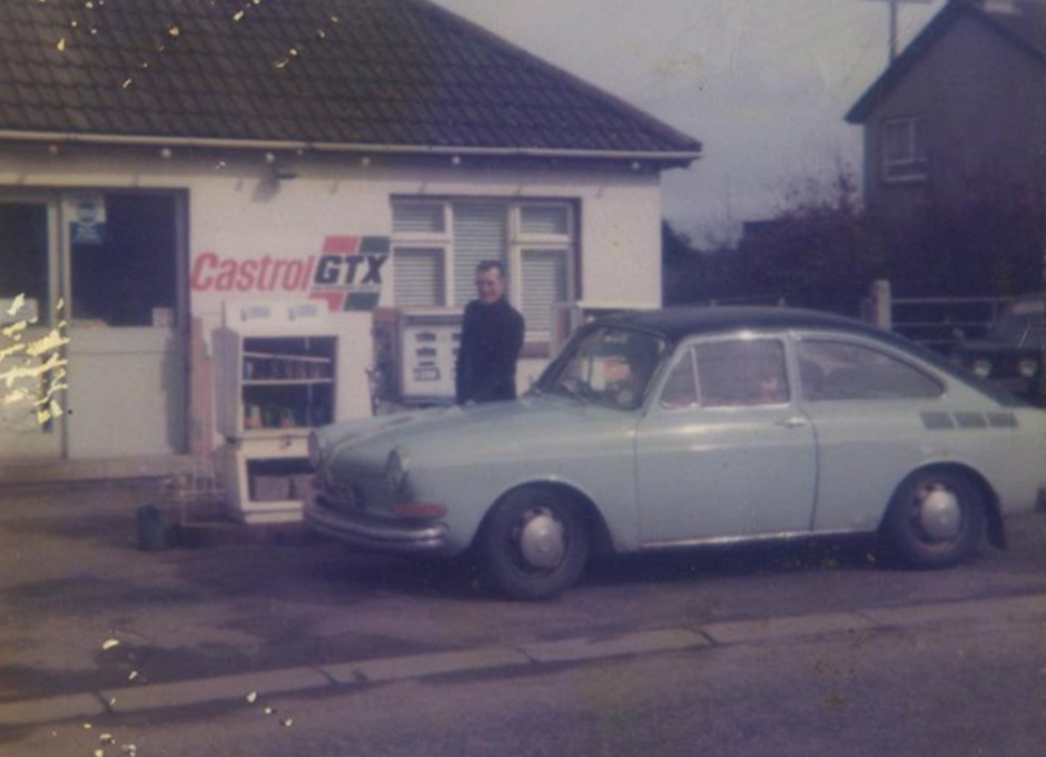 Historic photo of Tommy and Liz Murray’s petrol station with a classic car parked outside.